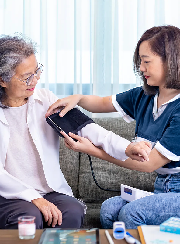 Young Woman Checking Blood Pressure of Older Woman in Holistic Healthcare Setting