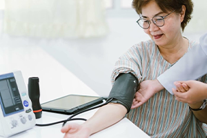 Clinician Checking Patient's Blood Pressure with Modern Equipment